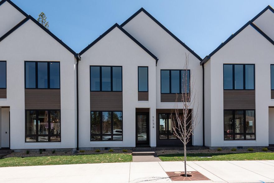 Scandinavian-inspired modern design with the award-winning craftsmanship of Structure Development NW in Discovery West. Trove Townhomes blend clean lines, contemporary finishes, and an open-concept layout, offering extraordinary living spaces. Great room with gas fireplace, custom built-ins and hardwood floors. Kitchen features professional appliances, large island and pantry. Dining area and covered patio are perfect for entertaining. The upper floor is highlighted by a stunning primary suite with vaulted ceilings, tile shower, radiant floors and a large walk-in closet. Two additional bedrooms, full bath, loft, laundry room and covered deck complete the upper floor. Garage offers ample storage, and the fully landscaped yard enhances the home's curb appeal. Located across from Discovery Corner Plaza, a vibrant hub for shopping, dining, and neighborhood events. Embrace a carefree, active lifestyle in the heart of Discovery West on the westside of Bend.