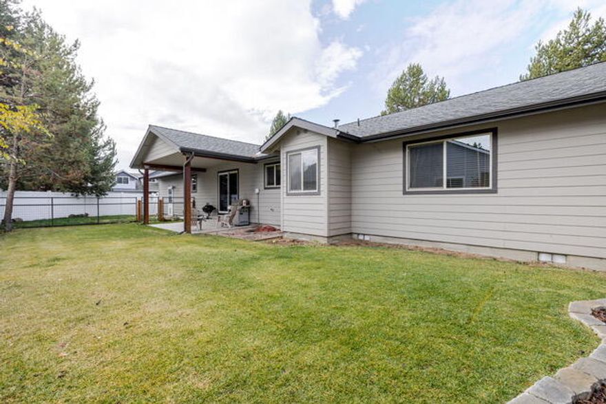 Built in 2005, this charming home is ideally located near the city park with a pickleball court. Featuring 3 bedrooms, 2 bathrooms, and 1,868 sqft. of living space on a .26 acre lot, it offers an open floor plan with vaulted ceilings and a spacious kitchen boasting generous work surfaces. Enjoy beautiful full wood-wrapped windows, descent sized bedrooms, a convenient mudroom, and distinctive built-in shelving, covered porch and deck. The roomy two car garage has workshop area. The property is beautifully landscaped with mature native plants and a sprinkler system. A fully permitted 200 sqft outbuilding, insulated and sheet rocked with a durable metal roof, makes a perfect office, workshop, or home gym. The large, fully fenced lot includes a dog run, kids entertaining center and plenty of room to enjoy the outdoors. RV parking is on site with water and power. Centrally located and close to all the recreation and amenities that Central Oregon has to offer — this home is a must-see!