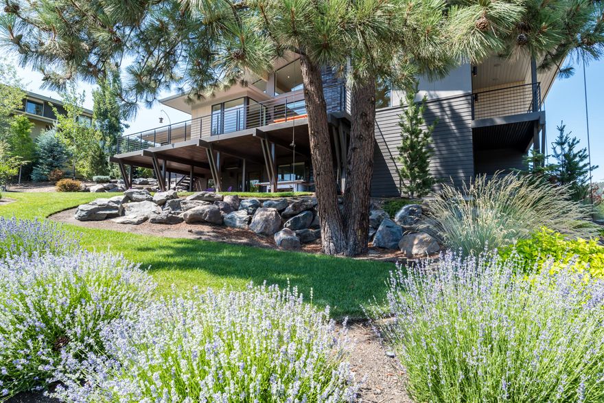 Stunning custom-built mid-century modern home overlooking Sunset View Park in the award-wining Northwest Crossing community, perfectly situated with direct access to the West Bend Trail, in walking distance to shopping and dining in both NWX & the popular Galveston corridor. Perched high above the street for privacy and views with south facing orientation and large windows to flood the home with natural light. Featuring luxurious finishes, clean modern lines and an open plan designed for entertaining that extends outdoors to the expansive deck and covered patio. The main level includes a private primary suite with balcony and spa-like bathroom including steam shower & freestanding soaking tub, a 2nd en-suite bedroom, office, powder bath and laundry room connected to a dog run, all with no-step access from the oversized garage. Floating stairs descend to a lower level bonus/media room with wet bar, wine room & cellar, two additional bedrooms & hidden flex space. Bend living at its best!