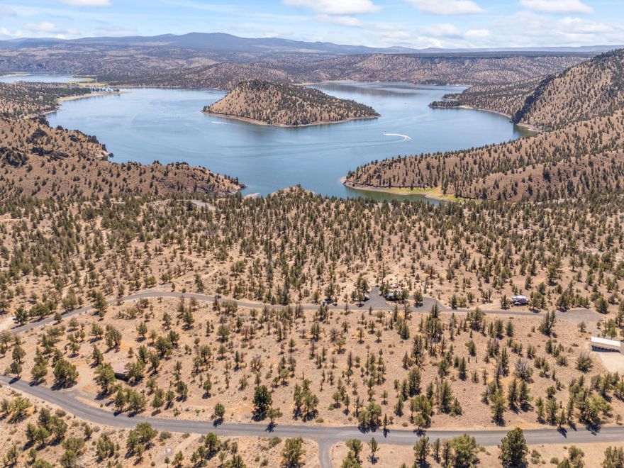 Beautiful 1.6-acre parcel with sweeping, unobstructed views of Prineville Reservoir! This rare opportunity combines four parcels into one build-ready lot with a strong 25 GPM well already installed. The driveway apron is in, utilities are available, and access is easy via a well-maintained gravel road. Gently sloped with mature trees, the setting offers both privacy and natural beauty. Just minutes from county and state boat ramps, this neighborhood of custom homes on large lots is the perfect location to design your dream home and enjoy the best of Central Oregon living.