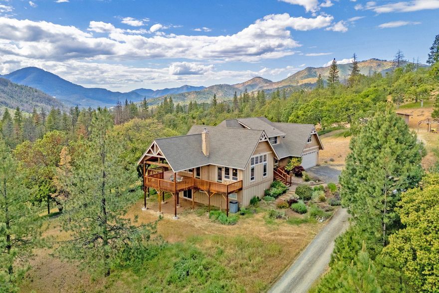 Looking for privacy, tranquility & a little piece of paradise? Imagine living in a beautiful custom-built home, far from noise & neighbors, yet only 20 minutes to Jacksonville. The house sits on 24 acres abutting BLM lands, w/ beautiful mtn views from every rm. The house features main flr living, anchored by a wraparound deck overlooking Dutchman's Peak & the valley below. The main flr entry leads into a large LR w/ vaulted ceilings, wood stove & a wall of windows w/ a peek-a-boo arch to the kitchen. The dining & kitchen are open w/ bar seating, stainless appliances, built-in eating nook, & a large pantry. The primary suite is spacious w/ a spa bath taking advantage of the views. The main level also includes a powder room, & a laundry rm leading to the 640 sf garage. The upper level includes an open rec rm w/ 3 bunk beds, 3 large bedrms, & a full bath. The lower level includes a large media room, office, powder rm, plus storage. Property also includes a 640 sf shop & full RV hookups.