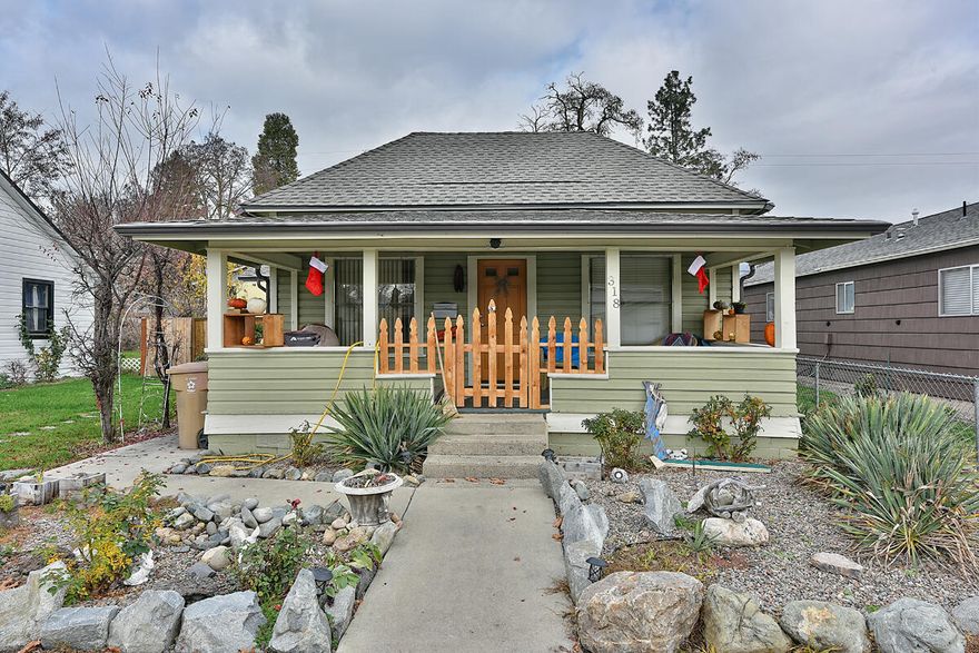Welcome home to this recently updated cottage in the heart of Grants Pass. Some of the updates include new flooring, remodeled kitchen and bathroom, newer exterior paint and roof, and fencing. This charming home has tall ceilings, oversized kitchen with a dining area and is all light and bright. Large living room with lots of natural light, 2 large bedrooms and an updated bathroom make this a great starter, rental, or retirement home! The charm continues when you step out on the large covered porch or take the stone path back to the fully fenced back yard. Large back yard great for animals, gardening, gathering with family. Detached garage/workshop has endless amount of options and would make a great art studio, workshop, play house, storage area, office ect. Very hard to find in this price range and this clean,