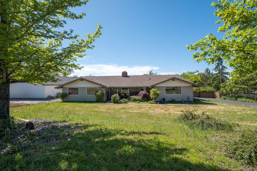 Graet Location! Discover your own slice of paradise located on the edge of town! This 2252 sq ft spacious home is situated on .53 acres, and offers 3 bedrooms, and 2.5 baths, plus an additional family room and formal dining area, that could be ideal for entertaining. The primary bedroom has an additional designated area for an office, workout area, or your own private retreat. Cozy up to the double fireplace in the living room and kitchenette and keep warm on those chilly days. Step outside and soak in breathtaking mountain views overlooking Grants Pass from your large backyard deck. You can shoot some hoops on the basketball court or possibly turn it into your private pickleball court. Gardening enthusiasts will love the backyard garden area and fruit trees. Whether entertaining, gardening, or enjoying outdoor activities, this home is waiting for your personal touch. Property may be sub-divided. Buyer to do their own due diligence with County and City.