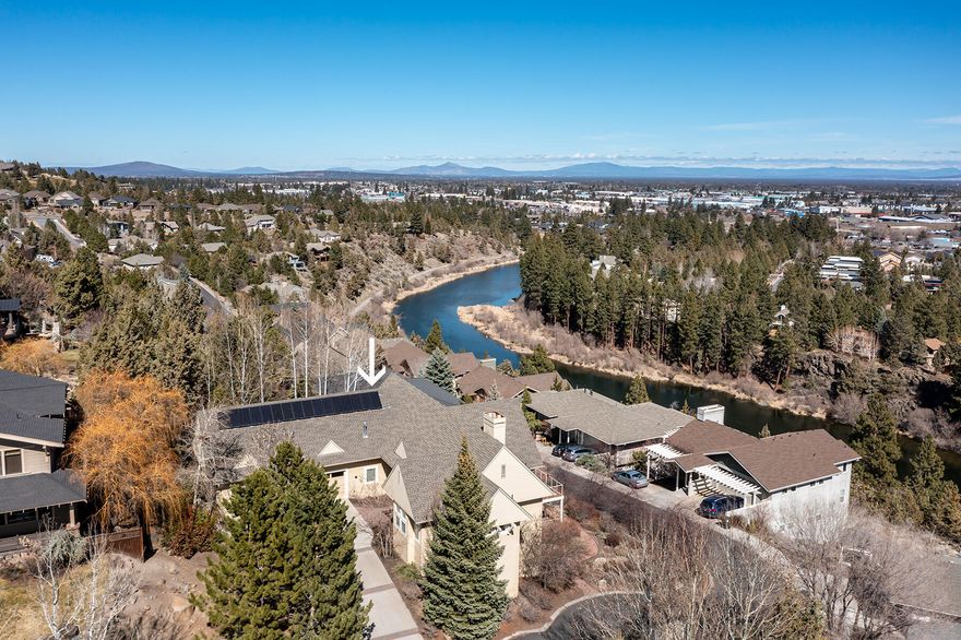 Custom luxury home, perched above The Deschutes River, just minutes from charming Downtown Bend, Oregon. Beautifully situated on large corner lot, quality abounds in this former Tour of Homes beauty with River, City and Pilot Butte views. Large wood framed windows showcase the beautiful, serene setting. Versatile floor plan boasts main level living with welcoming great room, built-ins, gas fireplace, spacious chef's kitchen, private primary suite with gas fireplace, and luxurious en suite with soaking tub and large tile shower. Expansive lower level features 2 spacious bedroom suites, plus bonus room with fireplace, closets and adjoining bath that could be a fourth bedroom suite. Enjoy watching the peaceful morning sunrises over Pilot Butte from the large deck or covered garden patio. You'll appreciate the neighborhood's easy access to the river trail that is minutes to the heart of downtown! Large South-facing driveway leads to oversize 3-car garage. Don't miss this gem!