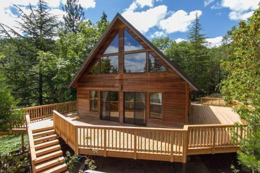 Discover this custom built home that rests in the trees on the edge of a beautiful meadow. The home offers a pleasant mix of wood, glass and skylights that drench the interior with natural light and peaceful views. The main level offers a living room, kitchen, pantry, full bath, large laundry room and family room that could be a third bedroom or office. The huge wrap-around deck creates an abundance of outdoor living space. The upstairs master suite opens to a large deck where you can enjoy peaceful privacy. Covered RV parking, huge detached garage/shop with 220 power, 4 car carport, 12' x 36' storage port and garden shed are some of the other features of this special 11.68 acres. Very private and yet just minutes to town. Come experience this special property today!