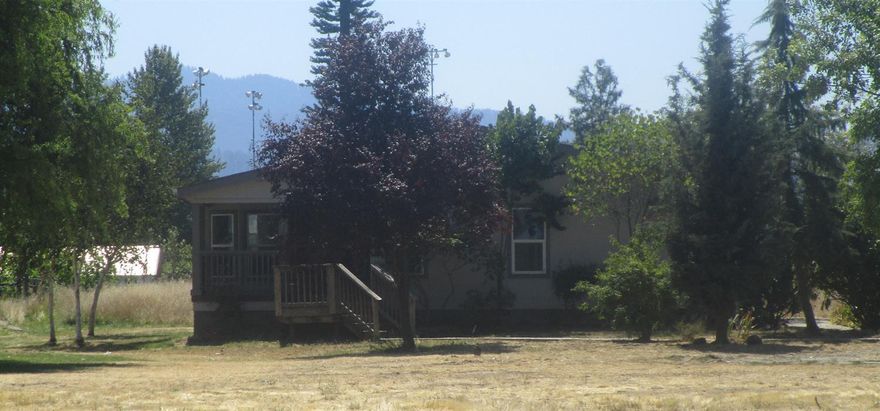 Good location for this 3 bedroom, 2 bath home. Large lot, 2.5 acres. Triple wide manufactured home gives plenty of living space. Property is irrigated. Additional cottage not permitted as a living area. Home needs some TLC including carpet, interior paint, interior doors and appliances.