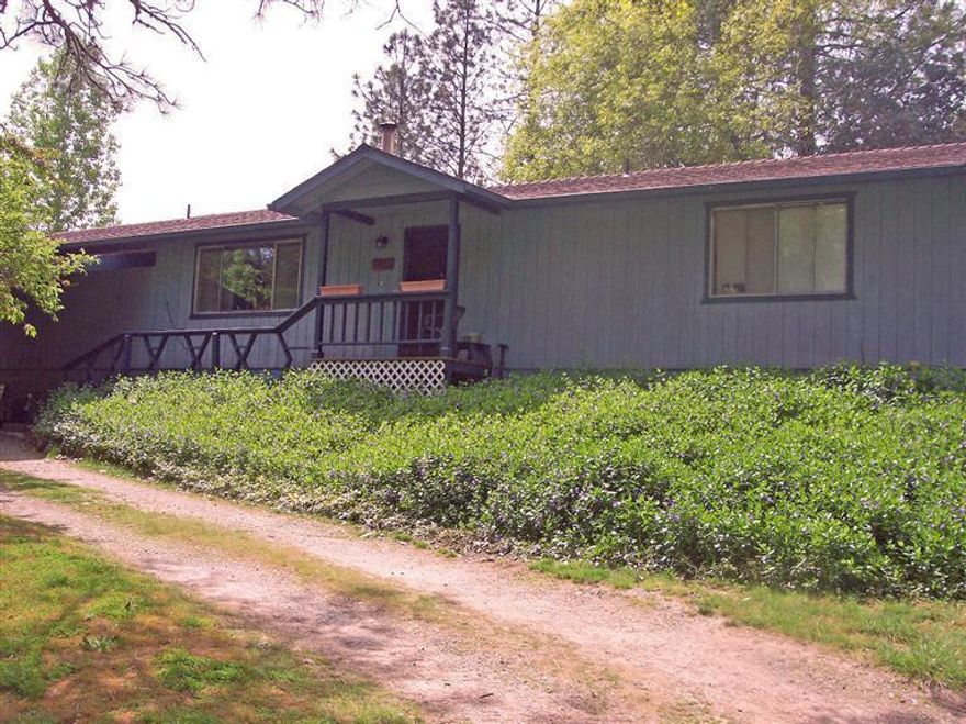 Beautiful setting for a great house! This house can be found up on a hill with lots of trees, flowers, and bushes all around it. It's the perfect spring scene. Inside the house you'll find 3 great sized bedrooms, 3 full bathrooms, a large living room with fireplace, nice dining room, and a convenient kitchen with lots of cabinets and formica countertops. Behind the home is a large covered deck with a large hot tub ready to use. Plus there is enough yard to grow your own garden and most of the back is fenced in, but there is still an area which is open and ready for badminton or running. Next to the main house is a shop that has a large bedroom. If you have company or an older child who wants some privacy, this is the place for them! There is also a 2-car garage by the shop while the main house has a covered carport and patio for relaxing. Come take a look. This might just fit your needs!