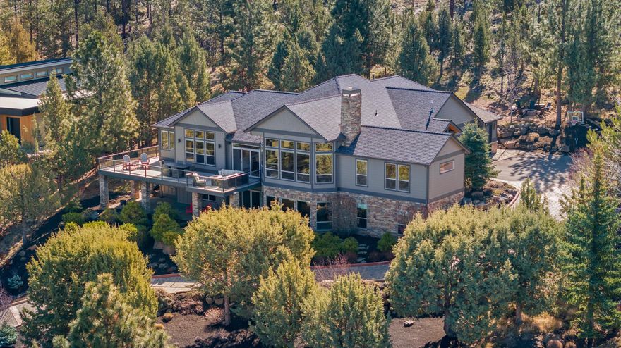 Updated custom home on Awbrey Butte. Soaring ceilings and expansive windows perfectly frame the panoramic vistas from every angle. The primary bedroom, 2 en-suites, and an office are located on the main level. In 2023, the kitchen was remodeled with custom cabinets, quartzite countertops, and top of the line Thermador appliances. The walk in pantry also includes new custom cabinets, granite countertop, and beverage frig. Downstairs, there are two additional bedrooms (5th bedroom is being used as a 2nd office), versatile rec room with pool table, a wet bar with seating, 200 bottle wine cellar, and a theater room—perfect for movie nights and entertaining. A second laundry room adds convenience to daily living. Numerous updates and upgrades to include a new fully heated paver driveway, new roof installed 2023, and new interior paint. Outside, an expansive wrap-around deck provides the ideal setting for outdoor entertaining or watching the amazing Central Oregon sunsets over the Cascades.