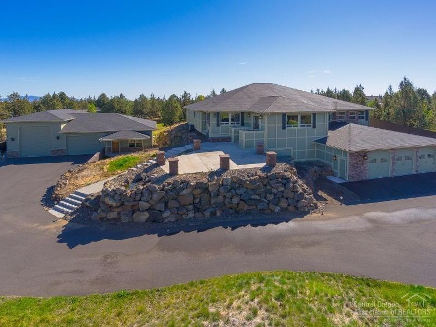 Extraordinary property in NE Bend on 2.5 acres w/spectacular Cascade views, garages for 7+ vehicles, shop & oversized RV garage w/hookups. Main house is a spacious 7,950 sf w/4 bedrooms, study, game room, home theater, & full size sports court. Rich finishes include hardwood floors, custom rock work, granite counters, & travertine tile. Fully fenced & gated w/1.75 acres of COI irrigation, water feature, covered back deck, tons of parking & an additional 780 sf apartment. This is an incredible opportunity!