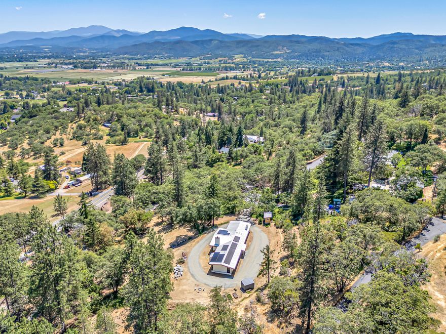 Discover this stunning single-level home located just minutes from the charming 
town of Jacksonville, situated on the highly desirable Old Military Road. Set on a private, 
gated 0.98-acre lot, this serene property offers captivating views of Mt. McLoughlin, with vibrant sunrises, colorful sunsets, and frequent wildlife sightings adding to the tranquil atmosphere. A picturesque tree-lined driveway welcomes you to a thoughtfully updated 3-bedroom, 2-bath residence. Inside, enjoy a beautifully remodeled kitchen, luxurious master bath, and updated laundry room. Recent improvements include a new electrical panel, recessed lighting, and a new septic system (2019). Energy-efficient features abound with solar panels, newer mini splits in every room, a newer wood stove for cozy winter nights, and an EV charger. Offering peace, privacy, and proximity to town, this home is the perfect blend of rural charm, modern convenience, and sustainable living.