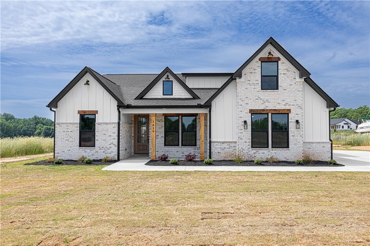 This modern farmhouse features striking gables and a welcoming covered porch, perfect for outdoor living