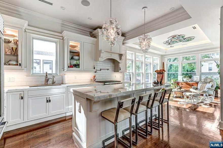 Welcome home to this completely renovated 2-Family Colonial home, which now lives as a truly spectacular Single Family Home. Located in the illustrious "Kings Bluffs" of Weehawken, this home is a true Gem. The grand entrance welcomes you with a 12 ft ceiling foyer, marble floors, restored mahogany walls, and a restored Mid-Century staircase. The second level offers an impressive and unmatched open floor plan, featuring a spacious primary Living Room, converted tranquil Family Room with a Walk-In Closet and private office space, a Designer Kitchen, Formal Dining Room, a gas fireplace, and a custom entertainment center. The elegant 10 ft tray and coffered ceilings with LED lighting set the perfect ambiance. The kitchen is a chef's dream with custom K che+Cucina cabinets, Quartzite countertops, and top of the line appliances including Subzero refrigerator, Wolf stove and Built-in Microwave Oven, Miele Dishwasher, and reverse osmosis filtration system, and of course, a breakfast bar.