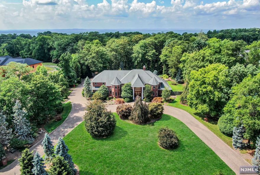 Welcome to this stunning, all brick colonial home nestled on 2 flat acres of mature landscaping. The home features very large rooms with soaring ceilings throughout the entry area (with a unique double staircase), dining room and great room. This very open floor plan offers an oversized kitchen, breakfast area and den that is ideal for entertaining or large family gatherings, living room, 2 powder rooms, laundry and a first floor primary suite with FP. 4 additional bedroom en-suites on the second floor with a reading nook plus a massage room. A full, finished lower level offers great space for a recreation room, additional rooms and full bath. With beautiful stone terraces, a free-form tile pool, hot tub and a four-car garage with ample additional parking, this home is perfect! VERY SPACIOUS WITH VIEWS!
