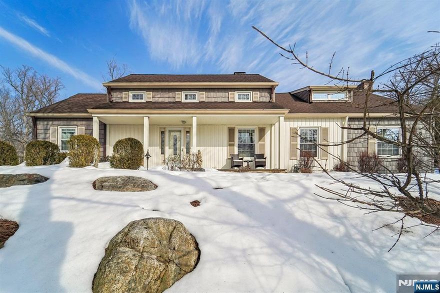 Welcome home to this lovingly maintained 4-bedroom, 2-bathroom Cape Cod set on a wooded lot in the Pines Lake community. A charming covered front porch offers a warm welcome for your guests. The entry foyer opens to a sunlit living room centered around a classic brick fireplace, creating an inviting space to gather for rest and relaxation. The family room, highlighted by vaulted ceilings, exposed wood beams, and its own brick fireplace, brings warmth and character ideal for cozy evenings or casual entertaining. The dining room, framed by a large window and a dual facing fireplace into the living room, flows into the thoughtfully designed kitchen featuring custom cabinetry, granite countertops, dual ovens, and generous center island that makes everyday feel spacious. A rear door leads to the patio, extending your living space outdoors for relaxed weekends and summer dinners. Two bedrooms and a full bath complete the main level. Upstairs, the primary bedroom offers two closets and access to a loft perfect for reading or reflection. Additional bedroom and bathroom complete the level. The partially finished basement includes a den, laundry, pantry, storage, and convenient garage access. A fully fenced backyard, 2-car attached garage, and ample driveway parking enhance everyday ease. Enjoy lake living with boating, fishing, swimming, pickleball, and tennis, all while close to NYC transportation, shopping, and dining offering the perfect balance of retreat and convenience.