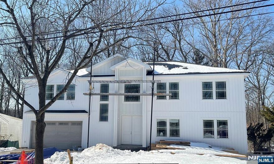 Welcome to this exceptional newly built residence offering approximately 4,600 sq ft of elegant living space plus a finished walk-out lower level. This thoughtfully designed home features 5 bedrooms and 4.5 baths with a dramatic 20-ft ceiling in the living room, red oak hardwood flooring, and expansive windows filling the home with natural light. The chefâ€™s kitchen showcases a stunning waterfall quartz island, premium appliances, and seamless flow ideal for entertaining. The private primary suite includes a walk-in closet and spa-inspired bath. The finished walk-out lower level with 9.5-ft ceilings provides flexible space for recreation, guests, or a home office. Exterior highlights include modern vertical siding with Azek trim, Andersen windows, a striking 96-inch entry door, paver driveway, full irrigation system, and fully fenced yard. An oversized garage with 11-ft ceilings and dual-zone HVAC completes this impressive offering. A rare opportunity to own sophisticated new construction in one of Bergen Countyâ€™s most desirable communities.