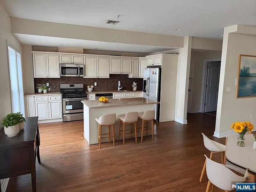 Extra Large Renovated 4-bedroom, 2.5-bath duplex apartment for rent in Harrison offering approximately 2,200 sq. ft. of living space. This spacious two-level unit features an open floor plan ideal for roommates or a larger household. The main level includes a generous living room, open kitchen with granite countertops, stainless steel appliances, custom cabinetry, one bedroom, and a half bath. The upper level offers three additional bedrooms and two full bathrooms. Additional features include central air conditioning, in-unit laundry, and hardwood flooring throughout. The building was constructed approximately six years ago. Convenient access to the Harrison PATH station and public transportation to Rutgers and NJIT.