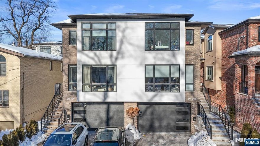 Welcome to a luxury living experience just two minutes from the George Washington Bridge. This exquisite duplex exemplifies superior craftsmanship and design, featuring elegant coffered ceilings and a stunning galley kitchen. The expansive living room, highlighted by a cozy fireplace, showcases meticulous attention to detail. The ground floor offers a spacious two-car garage, a convenient mudroom, and a versatile bedroom or office space complete with a full bath. On the first floor, the large living room invites warmth and comfort with its fireplace, while the chef's dream galley kitchen seamlessly connects to a charming dining area. A well-placed powder room enhances this level's functionality. Step outside to the deck, an ideal setting for relaxation and outdoor gatherings. Ascend to the second floor to find the luxurious master suite, featuring a sunlit master bath. Two additional bedrooms, a full bath, and a dedicated laundry area complete this level. This prime location offers easy access to NYC transportation, shopping, dining, and schools. Experience the epitome of luxury living with this exceptional property.