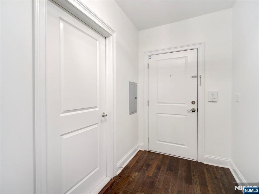 Welcome to this well-maintained 2-bedroom, 2-bathroom condo at the Lofts at Lincoln Park, offering modern comfort in a prime downtown location. Featuring hardwood floors throughout, the open-concept living and dining area is ideal for relaxing or entertaining. The updated kitchen includes granite countertops, stainless steel appliances, ample cabinetry, and a breakfast bar for casual meals. The spacious primary suite boasts a walk-in closet with custom shelving and a private en-suite bath with double vanity. A second bedroom and full bath provide flexibility for guests, a home office, or shared living. Additional highlights include in-unit laundry, recessed lighting, central air, and an assigned garage parking space. Residents enjoy a fitness center and private courtyard, all conveniently located near transportation, dining, and entertainment, with direct bus access to Newark Penn Station just steps away.