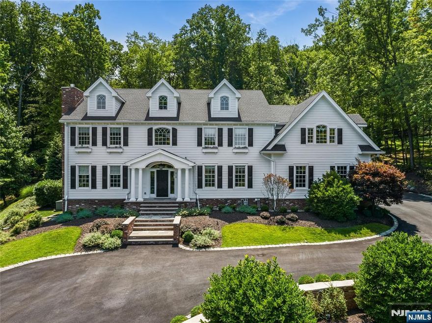 This custom-built 5 bedroom 4 bathroom, 2 half bathroom Colonial Set on 1.8 acres of meticulously landscaped grounds, exudes luxury and elegance. The breathtaking two-story foyer welcomes you to the main level, which includes a library, great room with fireplace, banquet-sized dining room, powder room with custom built-ins, laundry room, and a 3-season room with a brick fireplace. The gourmet kitchen is a chef's dream, featuring a large center island, built-in refrigerator and freezer, high-end stainless steel appliances, a built-in bar, and a butler's pantry. Separate dining area leads into the living room featuring floor to ceiling windows allowing beautiful natural light to fill the space. Retreat upstairs to discover the opulent primary suite which offers an extraordinary walk-in closet room, a spa-like bath with a soaking tub, walk-in shower, and dual custom marble vanities. The second floor also boasts 4 additional bedrooms, 2 full baths, and generous storage. A third-floor bonus room serves as a den, exercise space, or office. The fully finished basement is an entertainer's paradise, with a media room, full bar, recording room, Humidor Cigar closet, full bath, and additional storage. Outside, discover your private retreat with a custom patio, pergola, built-in fire pit, inground pool, and hot tub all backing up to the serene High Mountain Park Reserve. A paver circular driveway and attached three-car garage complete this exquisite home designed for luxurious living.