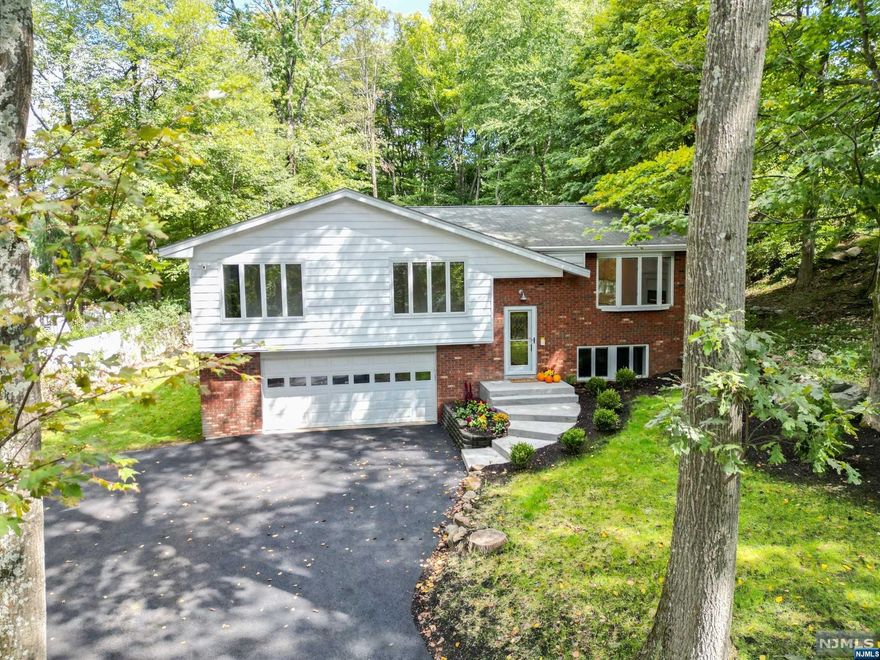 Over 5000 sq ft. This Custom 5-bedroom home w/ additional lower level living space has 6 full baths, 5 w/ toilet/bidet combos, 9 zone heating & a/c along with a two car oversized garage has it all. Brand new kitchen upstairs with tile floor, Calacatta quartz countertops, soft close cabinetry and new SS appliances that lead to a large deck. Gleaming H/W floors. Two large suites on the second level. M/B with jetted tub and separate shower. Huge walk in custom closet and windows that look out to the backyard. Junior-suite has a walk-in closet and full bath with jetted tub & shower combo. L/R w/ electric fireplace that changes colors to create a beautiful ambiance. D/R, Butler's pantry with wine fridge and three additional bedrooms on the other side one with its own bathroom and 1 additional bathroom has a tub shower combo. First floor has L/R, D/R, Kitchenette, Library, office, laundry room, workshop and an elevator.