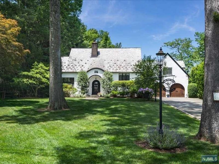 Exquisitely renovated to the highest standards, this Cotswold Tudor is a flawless combination of modern updates and old-world craftsmanship. Rich architectural details include a slate roof with eyebrow dormer and turret, rounded doors, beamed ceilings and leaded glass windows. Lovely Living Room with gas fireplace and office area opens to formal Dining Room. Eat-in Kitchen with high end finishes and appliances, built-in banquette, center island with breakfast bar and Pantry. En-suite bedroom off foyer offers first-floor sleeping space for guests. Mud room with built-in benches and cubbies, Sun Room, two powder rooms, rear stairs and lower level Rec Room. Fabulous primary suite with walk-in closets, cathedral ceiling and large bath with jetted tub, shower and double vanities. Three additional bedrooms (one En-suite and 2 with a Jack 7 Jill Bath) complete the second level. Fully fenced and beautifully landscaped rear yard features in-ground heated pool with shelf and waterfall.