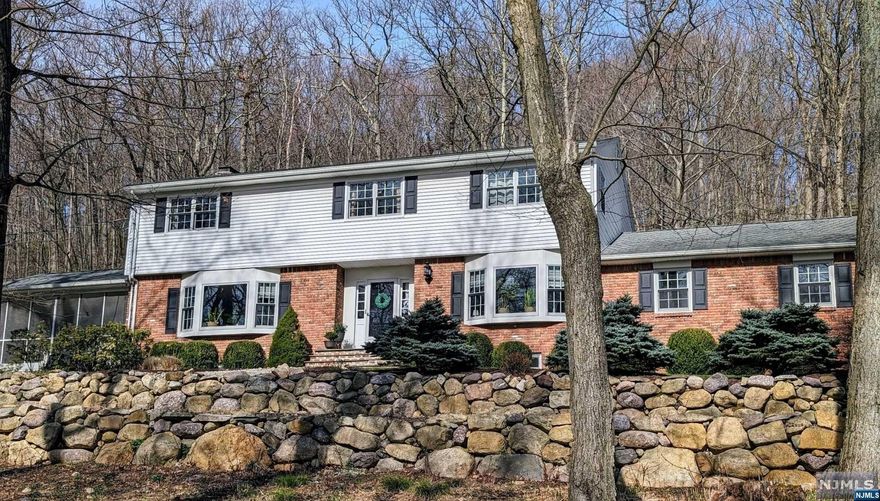 Opportunity to enjoy the Smoke Rise lifestyle and magnificent town of Kinnelon. Situated in the heart of the Smoke Rise gated community; walk to the Smoke Rise Beach! Quietly tucked away on 2+acres of privacy rests this charming 12-Rm Colonial. Most desireable floorplan to include bonus rm, full bath, laundry and rear yard access tucked off the Kitchen with convenient 2-car garage access! Large bright Kitchen with large sundrenched eating space! Rich Family Rm with fireplace quietly tucked off Kitchen with walls of glass to rear yard. Gracious grand foyer with Formal Dining Rm to right and Spacious Living Rm used as an office leading to fabulous screened-in porch! Beautiful Bay windows are appreciated in Living Rm, Dining Rm, Kitchen. Retreat upstairs to rich main bedroom suite w/soaring ceilings carried thru grand bath! Two spacious walk-in closets... The double main bath services 3 spacious secondary bedrooms. Rich hardwood flooring throughout upper level!