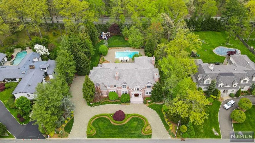 Experience luxury in this sprawling brick estate nestled 6 miles from NYC on Tenafly's prestigious East Hill. The grand front staircase, soaring ceilings & open floor plan will impress even the most discerning buyer. The spectacular Great Room w/fpl & lounge spill into a gourmet EIK. Flooded w/nat light & fitted w/Viking, Sub Zero & Miele appl. The open butlers pantry w/wine tower & dbl refrig drawers lead into a marvelous dining room w/fpl. A main flr bed/bath guest suite & office compliments the ideal 1st flr. The luxury continues upstairs w/4 generous BRs (2 ensuite) & lg Playroom/Bonus, all set apart from the Primary Bedroom Suite w/large Bath, dbl vanities, soaking tub & sep.WC. A sprawling LL features ample storage plus sauna, steam shower & Bath. The private outdoor oasis features an expansive patio, saltwater heated pool & new landscaping. Three car heated garage, generator & more. See spec sheet for full list of upgrades/amenities. Don't miss this one!