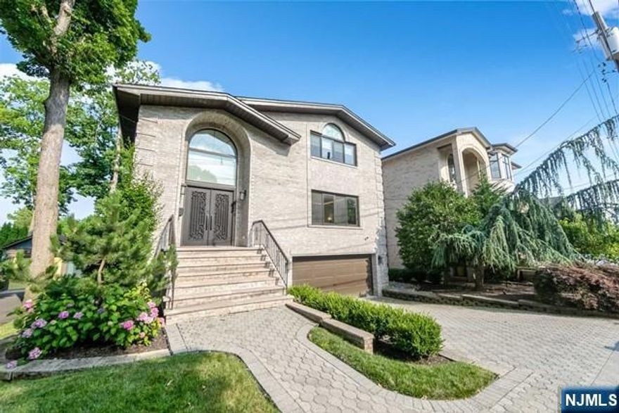 Step into this exquisite, recently renovated 5-bedroom, 4.5-bathroom luxury home in Fort Lee, NJ. The grand 2-story foyer leads to an open-concept design with seamless transitions. The sun-filled living room sets an elegant tone. The gourmet kitchen, equipped for all your culinary needs, features sliding doors leading to a spacious deck for outdoor dining and entertaining. The family room offers a bright space for relaxation. The dining room features a built-in bar, perfect for gatherings. A half bath completes this level. Upstairs, find four bedrooms and three full bathrooms, including the primary suite with ample closet space and a spa-like bathroom. The finished lower level includes a large recreation area, an additional bedroom, a full bathroom, garage access, and a laundry room. Outside, enjoy the covered patio overlooking the lush backyard.