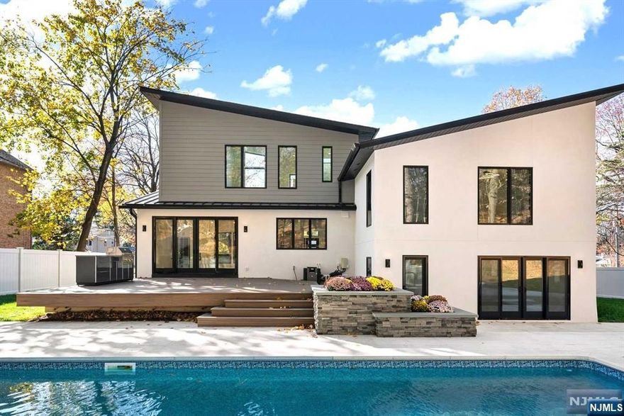 Located in the desirable East Hill of Closter, this modern new construction is sure to impress! Open layout with vaulted ceilings & oversized windows throughout, the south-facing home is flooded with natural light. Enter the main living area with fireplace adjacent to the dining room with glass doors opening to the most amazing outdoor space. Oversized deck with grill & stone patio overlooks lushly private grounds complete with a heated inground pool. Gourmet chef's kitchen with designer finishes, large center island & custom cabinetry provides the perfect place to gather with family & friends. Ascend to the airy upper level & relax in the great room or any of the spacious bedrooms including a luxurious primary suite with soaking tub. Third level has another soaring en-suite with marble bath & tremendous WIC. Finished ground level has a guest bedroom, full bath & access to the 3-car garage & yard. Truly stunning home designed for today's lifestyle. Enjoy the best of Bergen County!