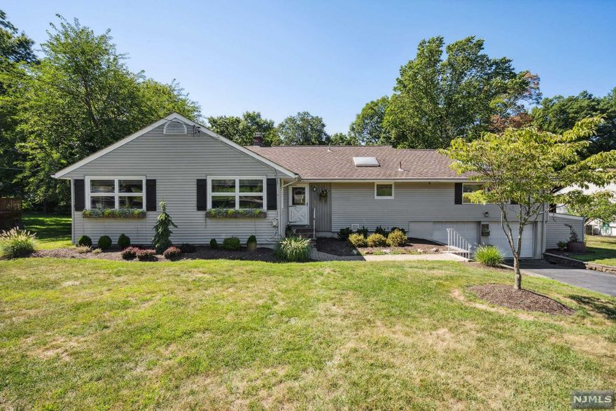 Bring the outdoors in through the large glass windows and 8 foot glass sliding doors!Hardwood floors in the bedrooms, living room and dining room. Primary en-suite with windows overlooking the backyard and private bath. Get your Zen on in the three-season porch - your perfect Hot Yoga Room. Love to entertain? The large deck will host a perfect outdoor party spilling out to the level lawn. The two car garage has a separate attached workshop with an outside entrance. The full basement is accessible from the two car garage - great storage and flex space. Your next movie night, weekend BBQ, and Sunday brunch await at 63 Evergreen Drive in North Caldwell!