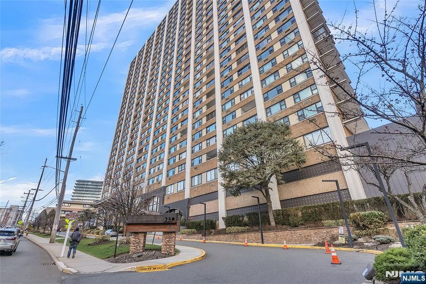 Experience elevated living at Apogee, situated on an elevated site offering unobstructed views of the NYC skyline. This renovated $1,235 sq. ft. residence features an open-concept layout with two bedrooms and two full bathrooms, including a primary suite. The kitchen is equipped with granite countertops, stainless steel appliances, and dark wood cabinetry, complemented by refinished hardwood floors throughout. A private terrace provides direct views of Manhattan. Building amenities include a swimming pool, kiddy pool, tennis courts, fitness center, community room, and a playground. The unit includes two dedicated parking spaces (one indoor and one outdoor), with additional tiered parking options available for a monthly fee. Located within minutes of NYC public transportation, local schools, and shopping, this property offers a comprehensive amenity package in a professionally renovated building.