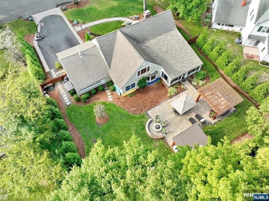 Step into this elegant, beautifully updated 4-bedroom, 3-full bath California-style ranch with over 2,760 sq ft of thoughtfully designed living space. New 2025 roof and new 2025 HVAC system. Modern elegance meets comfort in this open-concept layout, reimagined by one of Ridgewoodâ€™s premier contractors. The flexible floor plan easily accommodates both work and relaxation, making it ideal for todayâ€™s lifestyle. The welcoming entry leads to a spacious foyer, formal living room with a dual-sided fireplace, and a formal dining area. The sleek kitchen features high-end appliances, a breakfast bar, and flows seamlessly into a sun-drenched family room with floor-to-ceiling windows overlooking a stunning, fully fenced backyard oasis. Outside, enjoy a newer patio, picturesque cedar pergolas, a fully equipped outdoor kitchen, and a cozy gas fire pitâ€”perfect for entertaining or unwinding. The first floor includes a serene primary suite with a renovated ensuite bath, plus an additional bedroom and full bath. Upstairs, you'll find a second family room or office space with yard views, two generously sized bedrooms, an updated full bath, and a potential second laundry area. Additional highlights include a 2-car attached garage, and an unbeatable locationâ€”just steps from the school bus stop and convenient commuting options. Move-in ready and waiting to welcome you home!