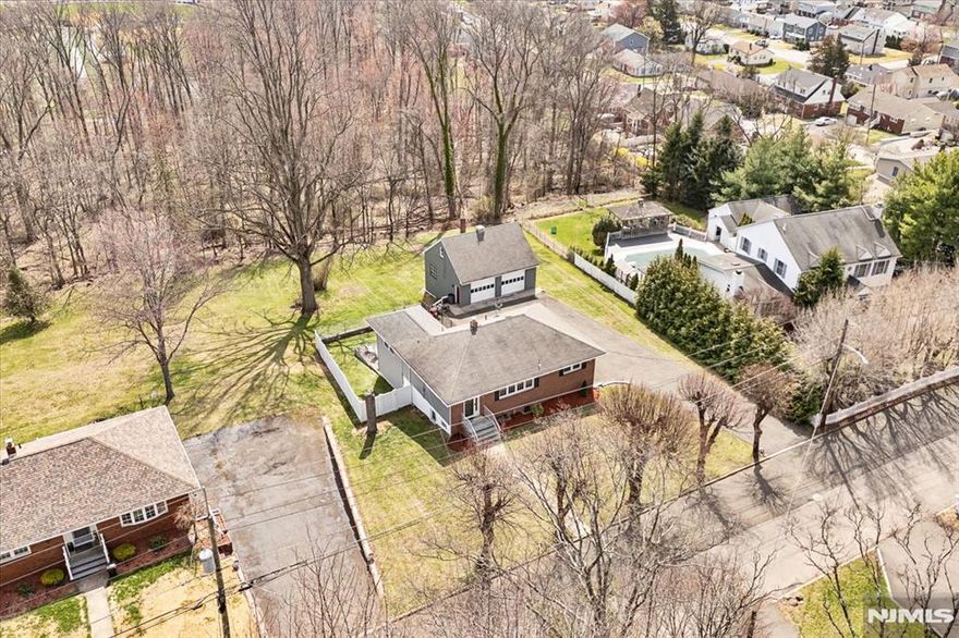 A rare find in Totowa! This custom brick front ranch with in-law suite potential is nestled on a quiet street that backs up to the PAL. Situated on a .67 acre lot, the main level offers 3 Bedrooms, full bath, updated eat-in kitchen with granite counters, vinyl floors and tile back splash, Dining Room, LR , Walk-up attic for storage, Family room addition with gas fireplace and separate heat w/entry to deck. The lower level with a separate ground floor entrance which walks out to the patio features a summer kitchen, dining room, 4th bedroom with huge walk in closet, full bath, living room/family room and a possible 5th BR. Hardwood floors, recessed lighting, central air, replacement windows, A mechanic's dream w/ a 2 Car heated garage & loft storage, huge driveway with parking for up to 20 cars! Oversized lot with vinyl privacy fence, underground sprinkler system, newer water heater (2022). All appliances included. Located on a very quiet street in town that backs up to the Totowa PAL. This is the one you have been waiting for! Home to be Sold in "As Is" Condition. Inspections limited to major structural, environmental and wood boring insects.