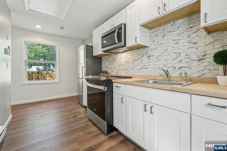 Welcome to your beautifully renovated 2-bedroom raised ranch, where comfort and charm come together in every detail. Step inside to a bright and airy space filled with natural light and stylish finishes. The gorgeous kitchen features classic white shaker cabinets and rich butcher block countertops perfect for cooking and gathering. You'll love the spacious full bath with sleek, modern fixtures, and the recessed lighting that adds a cozy glow throughout. Enjoy year-round comfort with ductless split AC units and beautiful wood laminate flooring that flows seamlessly from room to room. The inviting living room opens to a lovely deck through sliding glass doors, where you can take in breathtaking views of the river. Close to NYC transportation, shopping and restaurants. This is more than a home it's your own private paradise.