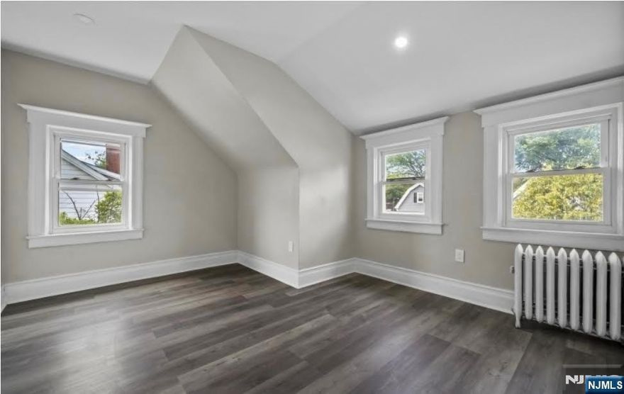 Beautifully maintained colonial-style single-family home on a quiet residential street in East Orange. Renovated in 2022, this home offers three levels of finished living space with 5 spacious bedrooms and 1.5 bathrooms. Features include an updated kitchen, upgraded electrical and plumbing, recessed lighting, hardwood floors, and attractive blue siding. The interior layout includes a welcoming foyer, sun-filled living room with bay window, bright dining area, and open kitchen. Enjoy a charming front porch, back deck, large backyard, and a driveway that fits up to 4 cars, with convenient access to NYC by bus or train.