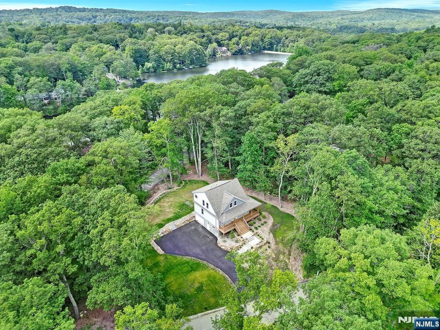 BRAND NEW CONSTRUCTION Colonial home ideal for a Primary Residence or Short Term / Long Term Rental property with incredible Lake Views situated on a private Corner Lot located in highly sought after year-round Resort town Vernon New Jersey within 50 mins from NYC! Custom wrap-around Porch leads to your very own private Deck and a MASSIVE Backyard making this home an Entertainers Dream. Upon entry you are greeted with an Open-Concept Floor Plan featuring a FIRST FLOOR BEDROOM & FULL BATHROOM, large Living Room & an Eat-In Kitchen including a Center Island with Breakfast Bar, modern Backsplash, Stainless Steel Appliances, Farmhouse Sink, & gorgeous Flooring all-throughout. Ascend upstairs where you will find a Primary Suite highlighted by an En-Suite Bathroom with Smart Mirror, Dual-Vanity Sink, Soaking Tub & ample closet space. Completing the Second Floor space is another Bedroom, Hallway Full Bathroom & private Balcony Deck with amazing Lake Views! The Full Finished Basement is your canvas awaiting your personal touches & creativity. Amazing Commuter location nearby Route 23 & Major Attractions; such as Breweries, Wineries, world famous Appalachian Trail hiking, Heaven Hill, Pennings & Blue Arrow Farm & year-round Resorts Crystal Springs, Minerals & Mountain Creek offering a Ski Resort, Waterpark, 7 premier Golf Courses & Mountain Biking.