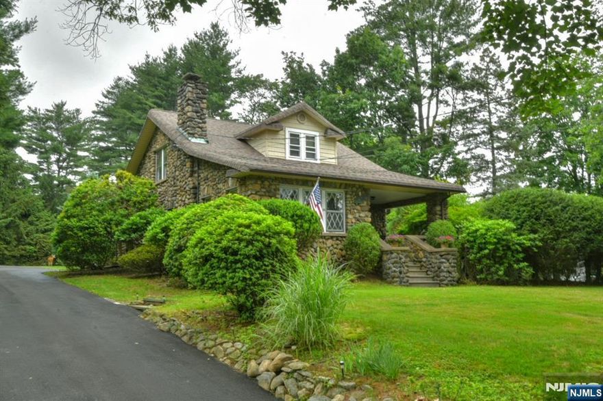 Discover this charming Waldwick home now available at a new, reduced price! Built with quality and character in mind, this lovely residence features 4 spacious bedrooms and 2 full bathsâ€”perfect for family living. The main level offers a generous living room, a welcoming dining area, and an eat-in kitchen, along with a convenient first-floor primary bedroom and bath. Upstairs, you'll find a second primary bedroom, two additional bedrooms, and a second full bath. The full, unfinished basement with high ceilings and Bilco doors presents excellent potential for customization. This home boasts beautiful original woodwork and hardwood floors throughout, adding warmth and timeless charm. Rest easy knowing the roof was replaced in 2025, providing peace of mind for years to come. Situated on a .66-acre lot atop a small knoll with a stunning stone exterior, the property offers privacy and wonderful outdoor space. An oversized detached garage with a loft provides ample storage, making this a fantastic opportunity for versatile living in a well-established neighborhood. Come visit today!