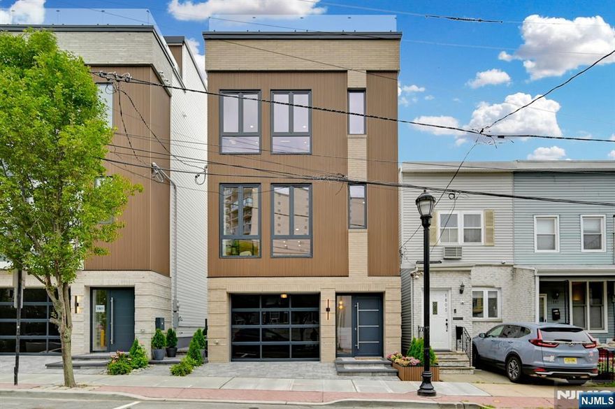 Welcome to the "Cliff Haus" at 1803 Cliff Street! Perched high above the cliffs overlooking Hoboken and Weehawken, this ground up single-family new construction home is above all: a high-end design/build on three levels plus a roof deck with amazing views of New York City, the Hudson River and Hoboken. Features include: 2,811 total square feet home on 3 floors, 750 sq.ft. roof deck with amazing views of New York City, the Hudson River, and Hoboken; 450 sq.ft. private, fenced in backyard; 2-car garage with glossy epoxy flooring; 9 inch ultra-wide hardwood flooring in White Oak (86" long planks); European tilt & turn windows in uPVC, double glazed; Window & garage door frames in trendy 'anthracite gray' color (RAL 7016); 10 ft. tall ceiling height on living/dining & kitchen level; 8 ft. tall windows; Oversized, solid interior doors; Custom wardrobes and walk-in closets with LED lighting; Imported porcelain tiles in all bathrooms, complented by Kohler & Grohe fixtures; European-style curbless walk-in shower in windowed primary bathroom; Custom kitchen, two-tone (cream and walnut) with paneled refrigerator and paneled dishwasher. High end quartz countertops with waterfall sides and full quartz backsplash 9" inch ultra wide hardwood flooring in White Oak; Bosch dishwasher; Bosch induction cooktop; KitchenAid wall oven /microwave combo; Thor paneled & built-in refrigerator; Kraus workstation kitchen sink;