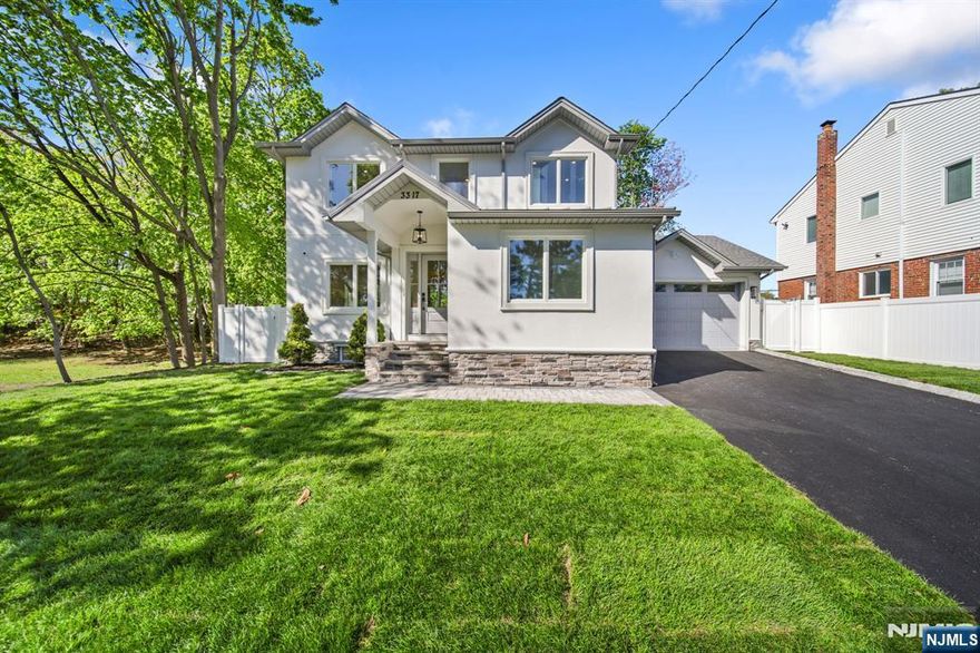 Set within one of Fair Lawns most desirable settings, this warm yet refined residence feels like home the moment you arrive. A long private driveway and two-car garage create a peaceful sense of arrival, setting the tone for a home that feels both private and inviting. Step inside through the mudroom or elegant front entry, where a paneled door with divided-light glass welcomes in natural light. A soaring foyer with a statement chandelier introduces interiors that are both polished and comfortable. The living room offers a cozy yet elevated space to unwind or gather, seamlessly connected to a beautifully designed kitchen featuring two-tone cabinetry, an oversized island, and premium stainless steel appliances. The kitchen flows into the dining area and family room, creating a natural gathering space that opens to a manicured patio and lush backyard, perfect for quiet mornings, play, or evening entertaining. A first-floor bedroom and full bath add ideal flexibility for guests . Upstairs, two spacious bedrooms with custom closets complement a serene primary suite designed as a true retreat, complete with dual closets and a spa-inspired bath with soaking tub, oversized shower, and double vanity. Convenient laundry hookups complete the level. The finished basement extends the homes livability with a rec room, wet bar, private bedroom, full bath, and ample storage. Close to parks, shopping, and NYC transit, this Fair Lawn home blends everyday comfort with understated luxury.