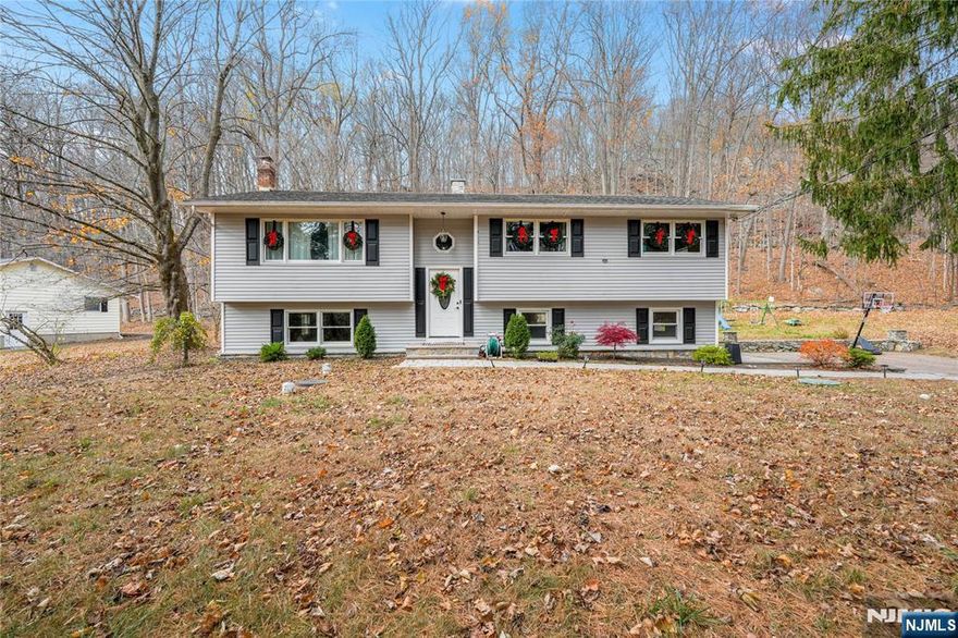 Tucked away on a quiet, secluded street, this beautifully renovated 3-bedroom, 2-bath home with en-suite bathroom blends modern luxury with everyday comfort. From the moment you arrive, you'll notice the impressive curb appeal new paver driveway, walkway, and patio, all accented with custom lighting. The backyard is an entertainer's dream featuring a built-in stone fire pit with seating and an expansive two-level deck.Step inside to a sun-filled open-concept kitchen, dining, and living area, anchored by a sleek linear fireplace surrounded by stunning stonework. The newly redesigned kitchen boasts a center island, brand-new cabinetry, granite countertops, and stainless steel appliances, with brand-new sliders that open directly to your outdoor living space.The exceptional main bathroom feels like a private spa, showcasing double sinks, a freestanding soaking tub, and a luxurious separate shower.The lower level offers a spacious family room complete with a wood-burning stove, ideal for cozy nights in. A beautifully renovated full bath features a waterfall rain-shower system, and the laundry area is conveniently located on the same level. Brand new septic tank has been installed !With a 2-car garage, modern upgrades throughout, and designer finishes in every corner, this home truly checks every box.