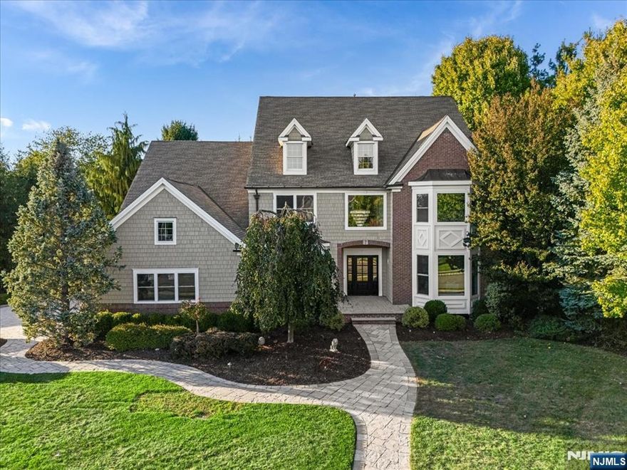 Set within the exclusive Grande at Pleasantdale, this meticulously reimagined residence blends timeless architecture with a sophisticated modern aesthetic. A striking exterior of cedar shake siding, brick detailing, and architectural windows sets the tone for the elegance found within. Step inside to a stately, light-filled interior showcasing wide-plank white oak flooring, custom millwork, and designer lighting throughout. The formal living and dining rooms exude refinement with coffered ceilings, wainscoting, and large picture windows that flood the rooms with natural light. At the heart of the home lies a spectacular two-story great room featuring a floor-to-ceiling fireplace, elegant trim detail, and open sightlines to the chefâ€™s kitchen â€” a true showpiece with a massive waterfall island, sleek quartz counters, professional-grade stainless appliances, and an adjoining breakfast area overlooking the lush backyard. Off the kitchen is a sun-drenched vaulted conservatory framed by a dramatic stone fireplace and an expansive wall of sliding glass doors that fully retract to create a seamless indoor-outdoor flow, opening the living space entirely to the yard and patio â€” perfect for al fresco entertaining and effortless gatherings. The luxurious primary suite offers a spa-inspired bath with floor-to-ceiling porcelain tile, a freestanding soaking tub, rainfall shower, and LED-lit vanity wall, creating the ultimate sanctuary.