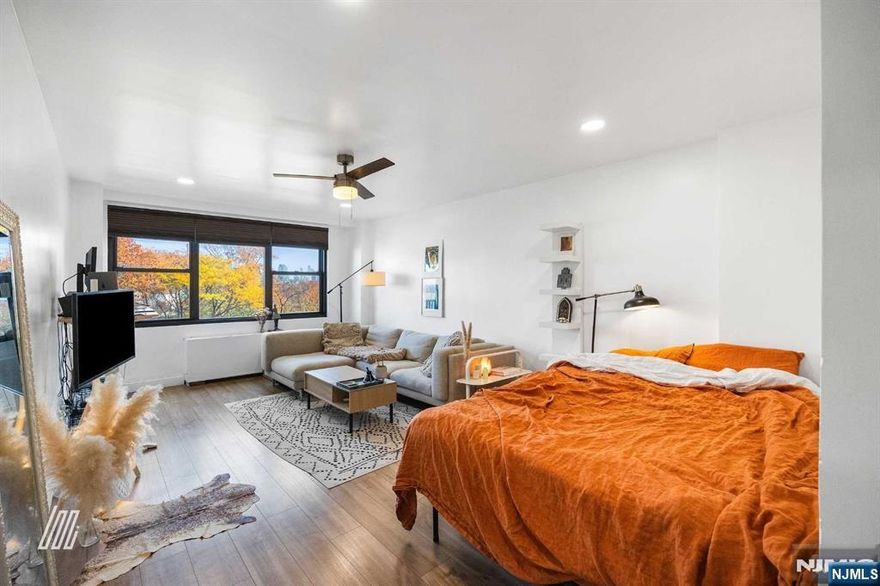 Charming studio apartment in an unbeatable location, just four blocks from the JSQ PATH Station. This 458 (appx) sqft gem offers wood style floors throughout, abundant natural light from large windows, nicely painted interior, and a spacious kitchen with ample cabinet space. Monthly HOA fees cover heat, hot water, cooking gas, and central A/C. Parking is available for added convenience. Enjoy the best of city living, with round-the-clock doormen and security staff ensuring peace of mind. This is your chance to be part of Journal Square's exciting revival a neighborhood blending historic charm with a vibrant future. From luxury high-rises to A-list entertainment and trendy coffee shops, Journal Square is redefining urban living. Don't miss out on this incredible opportunity! Additional fees by request: Parking($105-$110/month), gym($200/yr, $110/6 month, $60/3 month), pool(fee varies every year).