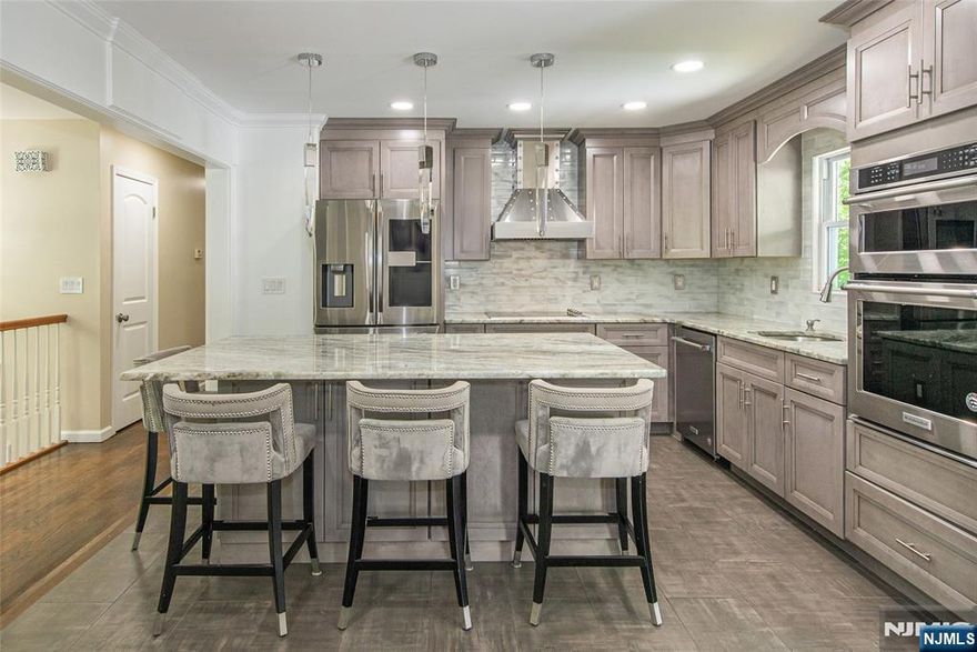 Welcome to 11 Ginger Ln. in Sparta. Tucked away on a quiet street in the desirable Sparta Mountain, this beautifully updated bi-level home combines modern comfort with the charm of nature. Situated on nearly half an acre (0.46 acres), the open-concept layout is bathed in natural light and designed for easy living and entertaining.The recently renovated kitchen is a standout feature complete with premium KITCHENAID appliances, an oversized granite island, and sleek, contemporary finishes. Just off the dining area, a spacious deck offers serene views of the lush, tree-lined backyard perfect for relaxing or hosting guests.The lower level adds valuable living space, featuring a cozy family room with a wood-burning stove, plus an additional room ideal for a guest suite or home office. CURRENTLY USED AS 4TH BEDROOM, this space boasts full-size ground-level windows and a closet, making it a versatile option. A walk-out leads to a second deck/patio area, extending your outdoor living space. Residents of Sparta Mountain enjoy access to nearby lakes and scenic trails ideal for hiking, fishing, kayaking, and year-round outdoor recreation. Whether you're looking for a move-in-ready home or a tranquil retreat surrounded by nature, this Sparta gem has it all. Don't miss out schedule your private showing today!