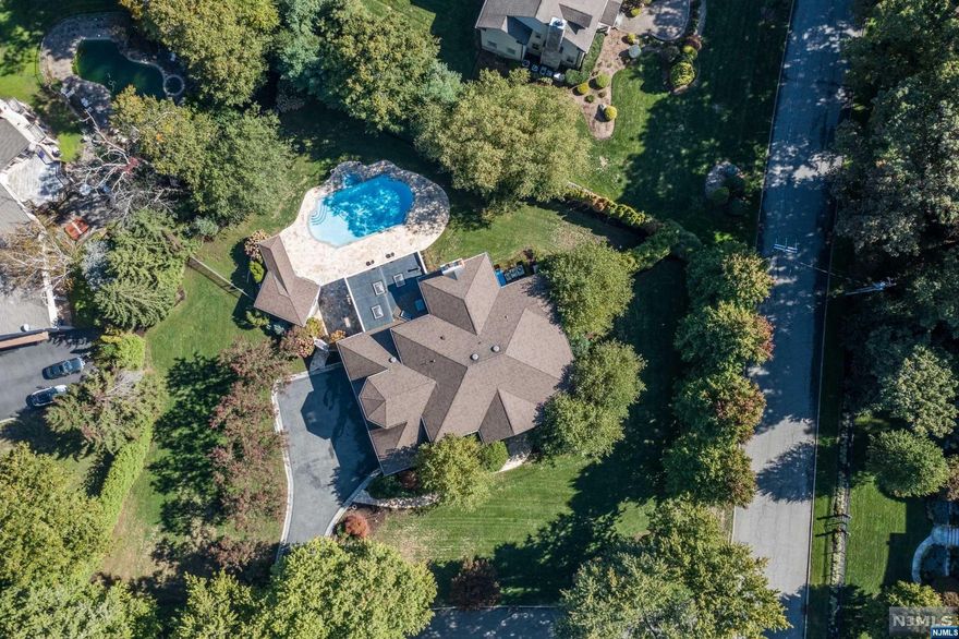 A magical oasis with lush landscape envelopes you into a fairy tale resort-like property upon arrival. A covered patio featuring a fireplace and pizza oven, overlooking the heated gunite pool and cabana, suitable only for the most discerning buyer who understands luxury. Stunning 18' entry foyer with custom trim work, formal LR, banquet sized DR, a great room with coffered ceilings and a wet bar to showcase your private collection. A custom cherrywood office is the perfect spot to transact your biggest deals. On the 2nd floor you will find the gorgeous primary suite with fireplace, and spa like bath with a steam shower, 4 additional bedrooms and a laundry. Full finished basement with a full bath and wine cellar. The home features a 3 car garage with 2 lifts. This home checks all of the boxes.