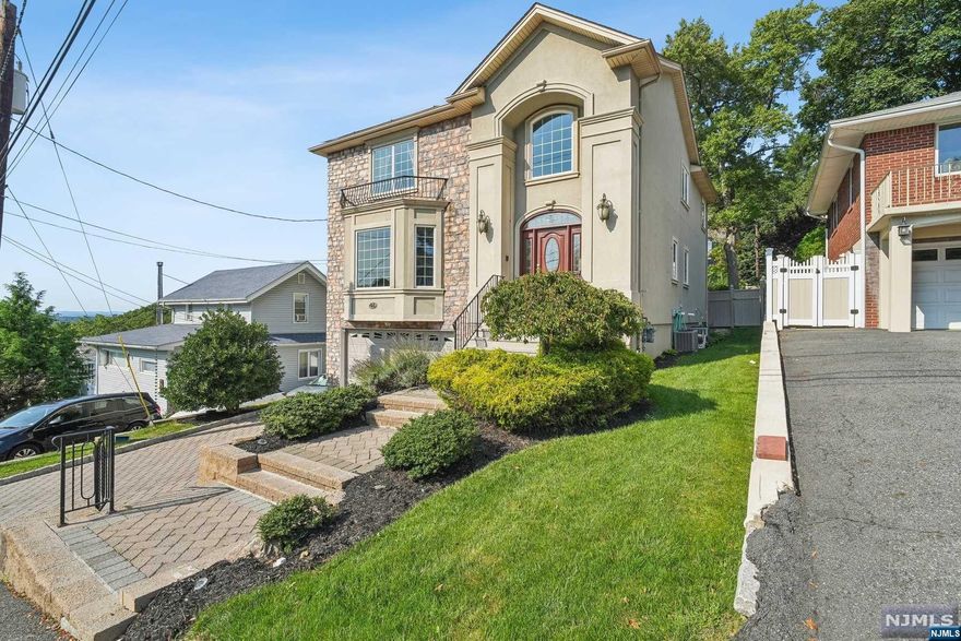 Discover exceptional living in a meticulously maintained 4,230 sqft home that blends modern elegance and comfort. This 5br, 4.5bath features hw floors, expansive Anderson windows, and soaring ceilings, creating a bright, airy atmosphere. The open layout includes a double-height foyer, spacious living rm with wet bar, formal dining rm, and a gourmet kitchen with a granite island and high-end appliances. Upstairs, four versatile rooms and three baths offer flexible living spaces, while the finished bmnt provides independent living quarters. Enjoy sunset views from the lush backyard oasis, perfect for both entertaining and everyday life. Highlights include a primary spa-like bathroom, central vacuum, two gas fireplaces, two walk-up attics, and a 2-car garage. Recent upgrades include a new d/w, water heater, fresh paint, and solar panels. Nestled on a quiet residential street, the home is close to shopping, dining, Engwd pvt schls, easy access to Rt 4, NYC, and GW Bridge.