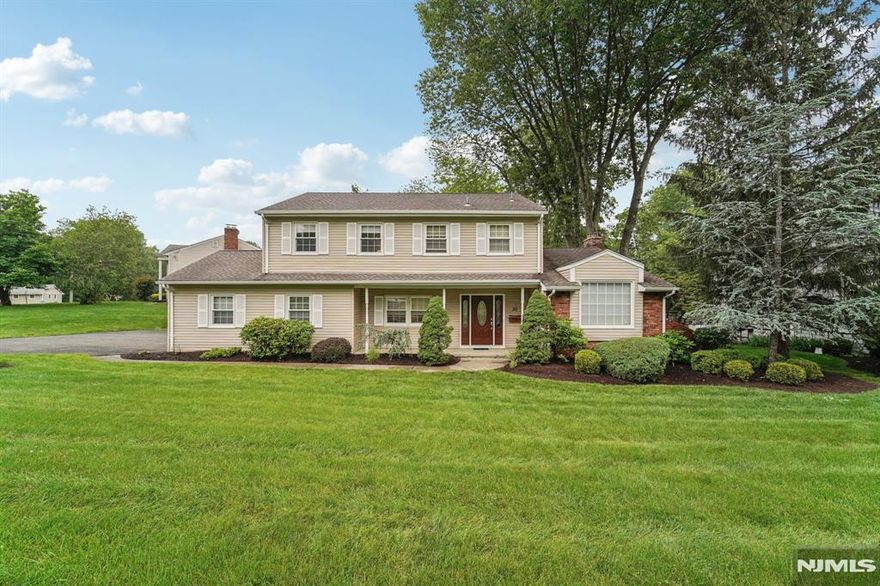 Welcome home to this well-maintained 4-bedroom, 2.5-bath Colonial nestled on a beautifully manicured, level lot in the heart of Wayne. The welcoming entry foyer leads into a bright and spacious living room, perfect for relaxation and conversation. An adjacent formal dining room offers the ideal setting for intimate meals or festive gatherings. A large cased opening flows into the eat-in kitchen featuring custom cabinetry, granite countertops, a stylish backsplash and a casual dining area. Laundry is in the kitchen. A rear door leads to the backyard for easy outdoor access. The cozy family room boasts a brick fireplace and is ideal for movie nights or entertaining. Sliding glass doors with screens open into the expansive sunroom an inviting space to enjoy your morning coffee or evening cocktail and continue out to the rear deck, perfect for outdoor dining and summer get-togethers. A powder room and garage entrance add convenience to the main level. Upstairs, the spacious primary suite offers a large closet and private bath. Three additional bedrooms, one currently used as a home office, and a full hall bath complete the second floor. The partially finished basement provides flexible space for a den, home gym, office, or hobbies. The wooded backyard offers endless opportunities for gardening, play, or simply unwinding in nature. 2-car attached garage and ample driveway parking. This warm and versatile Colonial blends everyday comfort with effortless entertaining inside and out.
