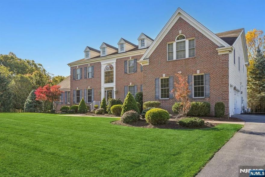 This Stately Brick Colonial, situated on a 3/4 lush acre lot in one of North Caldwell's most sought-after neighborhoods, offers over 5,000 sq ft of luxurious living space. Built in 2008 & meticulously maintained by its original owners, this home combines timeless architecture with modern amenities. A grand marble foyer leads to a spacious living room & sun-filled conservatory that shares a double-sided fireplace. The chef's kitchen is impressive with a generous center island, granite countertops, custom cabinetry, 2 dishwashers, 2 double wall ovens, & convenient wet bar that opens to a dramatic 2-story family room complete with its own fireplace. 1st floor bedroom, full bath, & laundry room provide added convenience. Gorgeous hardwood floors, custom built-ins, & exceptional trim detail throughout! Upstairs, a striking landing leads to 4 well-appointed bedrooms. Primary suite is a true retreat, featuring 2 walk-in closets, gas fireplace, office/sitting area, & spa-like ensuite with double sinks, jetted tub & stall shower. 2nd bedroom features its own private bath, while 2 additional bedrooms share a Jack-&-Jill bath. Finished lower level offers endless versatility, featuring home gym, large rec room, & additional full bath. Enjoy outdoor living on the expansive stone patio, complete with built-in kitchen in fenced yard. Additional highlights include a 2-zone HVAC system, underground sprinklers, & thoughtfully designed landscaping that enhances the home's curb appeal.