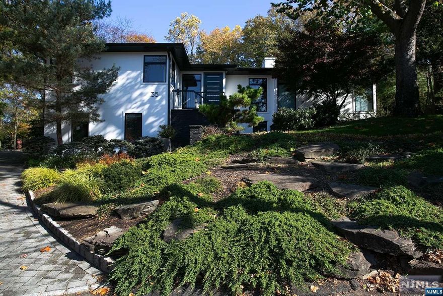 Gut renovated from the inside out, this over 6,000sf California Modern home on the East Hill of Tenafly offers a spacious open floor plan replete with floor to ceiling windows allowing panoramic views of the outdoor limestone patio and salt water pool. Entertaining will be a dream with the stunning PoggenPohl designer kitchen. The double sided fire place connects the oversized family room to the stylish living room and the indoor/outdoor room provides the perfect area to relax in those colder months while enjoying your backyard retreat, hot tub and out door kitchen. Luxurious primary suite with ample his/her closets, a wall of windows and access to the spa like pool and property. 3 further bedrooms with their own bathrooms fill the second floor. Other features include a gym complete with dry sauna, a full house generator, home office and private entrance to ground floor bed/bath suite. This spectacular home is located 8 miles from the GW and close to award winning schools.