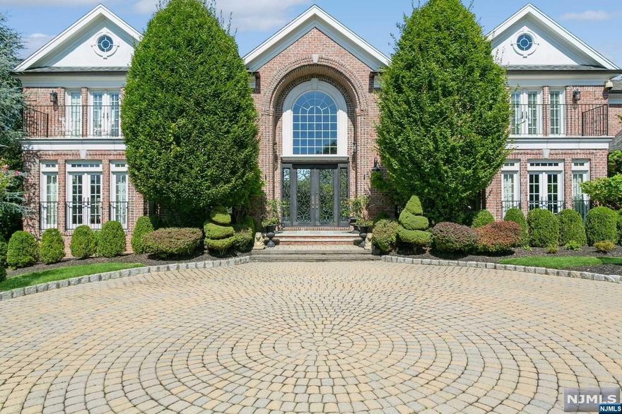 Nestled on 1+ flat acres on Tenafly's prestigious East Hill, this beautiful brick estate offer's meticulous landscaping, oversized pool, custom gates and copper gutters. Side by side iron front doors lead to a double foyer and a stunning butterfly staircase. The family room with gas fireplace flows to a formal living room, office & intricately designed exterior brick terrace. The dining room adjoins a gourmet kitchen & butler's pantry. The ground floor includes a guest bdrm & bath, laundry and garage access. The left wing hosts the primary suite, round living room, dual closets, french doors to a balcony & luxurious bath. The right wing boasts 3 bdrms & baths with a room to finish into an add'l bdrm. The bsmt offers a state of the art cinema, gym, wine cellar, recreation room, bdrm and 1.5 baths. If that is not enough.. the most sensational sunsets illuminate the entire home.