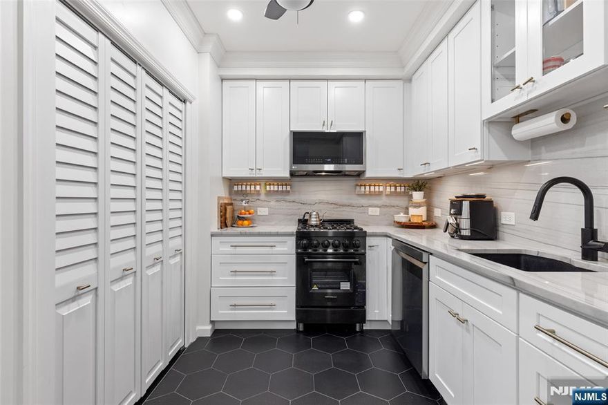 Private patio living in the sought-after Hamilton Park area of Downtown Jersey City, this beautifully renovated two-bedroom home combines modern upgrades, classic architectural charm, and an exceptional location just moments from all Jersey City offers. Situated on the first floor of a well-maintained boutique three-unit pet-friendly building, this thoughtfully designed residence offers approximately 851 square feet of comfortable living space along with a private covered patio featuring a retractable awning and lighting - perfect for outdoor dining, entertaining, or relaxing. The designer-renovated kitchen showcases quartz countertops, white shaker-style cabinetry, subway tile backsplash, under-cabinet lighting, stainless steel appliances, and striking black hex tile flooring. A brand-new in-home washer and dryer adds everyday convenience. The bright living and dining areas feature bay windows, crown molding, recessed LED lighting, and dark-stained hardwood floors. Both bedrooms are well-proportioned, with the primary bedroom offering a custom closet system. The second bedroom works perfectly as a guest room or work-from-home office The bathroom has been tastefully updated with classic white subway tile and a Carrara marble-top vanity. Additional highlights include efficient mini-split heating and cooling, ceiling fans, and a large under-stair storage closet. For added buyer confidence, the seller will provide a one-year home warranty through Assurant at closing